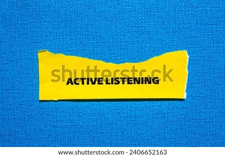 Active listening lettering on ripped yellow paper piece with blue background. Conceptual photo. Top view, copy space.
