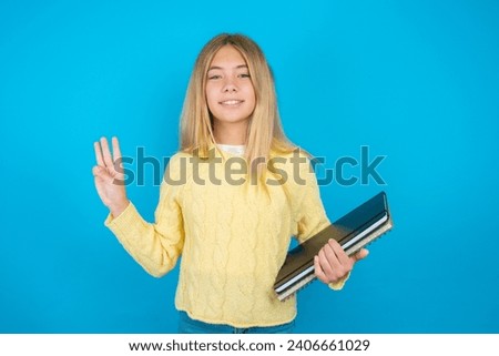 beautiful caucasian teen girl  showing and pointing up with fingers number three while smiling confident and happy.