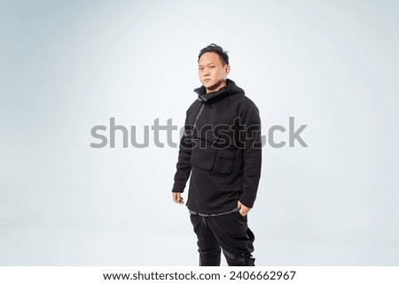 photo shoot of a Korean guy on a white background. A Korean model in a fashionable winter hoodie. photo shoot of youth clothes with a model in a photo studio