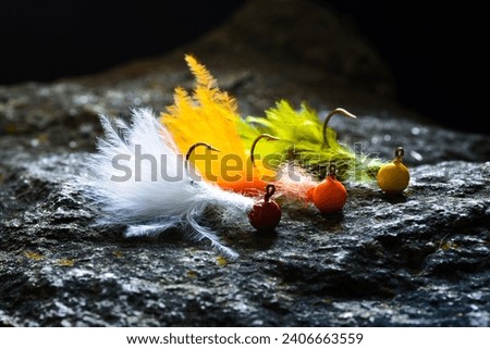 Group of colorful jig streamer made of feathers on gray stone Royalty-Free Stock Photo #2406663559