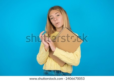 Surprised emotional beautiful caucasian teen girl rubs palms and stares at camera with disbelief