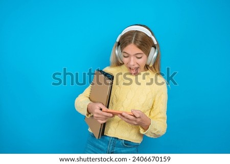 Portrait of an excited beautiful caucasian teen girl playing games on mobile phone.