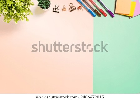 Minimal work space - Creative flat lay photo of workspace desk. Top view office desk with adhesive note on pastel green pink color background. Top view with copy space, flat lay photography.