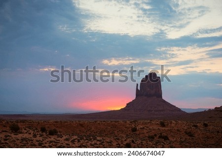 Monument Valley view at sunset with wonderfull cloudy sky and lights on mittens