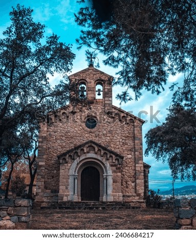 Catholic church located in Catalonia neighborhood. Red brick building surrounded by trees. Typical countryside religion building in Spain. High quality picture for wallpaper, article