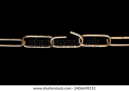 Steel chain with shiny brass plated surface, and with one link bent open, over black. Straight shaped smooth, decorative ring chain, made of round wire, with rounded links, made of brass plated steel. Royalty-Free Stock Photo #2406698151