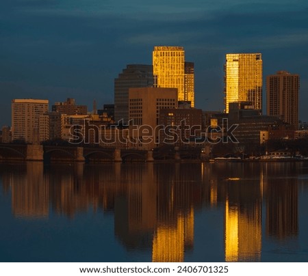 Boston skyline and reflection in Charles River at sunset on a winter day