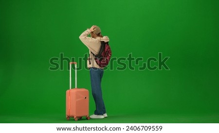Portrait of person tourist isolated on chroma key green screen background. Young woman looking at the departure board, late to flight, upset expression.