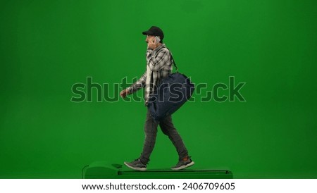 Portrait of person tourist isolated on chroma key green screen background. Adult man in cap with sport bag walking and talking on smartphone.