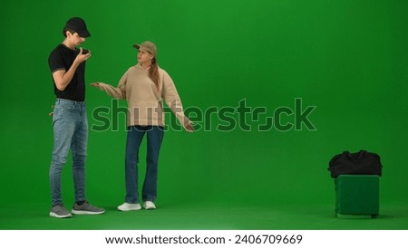 Portrait of person tourist isolated on chroma key green screen background. Young woman standing and talking with security man about luggage issue.