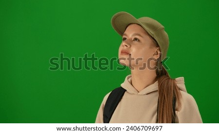 Portrait of person tourist isolated on chroma key green screen background. Close up shot young woman looking at the departure board flight information.