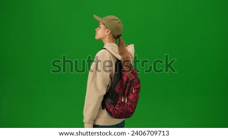 Portrait of person tourist isolated on chroma key green screen background. Close up shot young woman standing and looking at the departure board.
