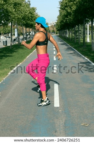 In the photo taken from the profile; The female athlete is preparing for a run and doing warm-up exercises.
