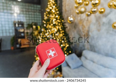 First aid kit against the background of a Christmas tree, a red small box with medicines. High quality photo