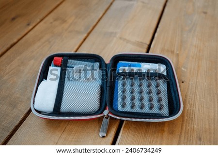 An open first aid kit with medicines is lying on the table, a pressure of medicines for personal use, an emergency first aid kit, pills for pain. High quality photo