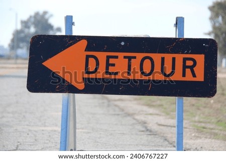 A temporary detour sign reroute traffic to the left.