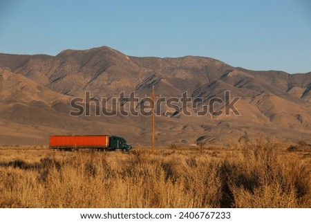 A big rig truck hauls goods across the desert Royalty-Free Stock Photo #2406767233