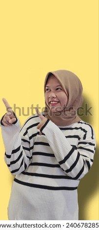 Happy Asian girl wearing hijab pointing to the something,  indonesian women wearing hijab pointing to the something. Asian women 