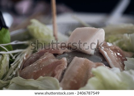 Thai bbq buffet with pork, chicken and other meats, cooked on a brass barbecue pan or Moo Kra Ta in Thailand language. Royalty-Free Stock Photo #2406787549