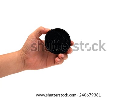 Hand holds Lens cap on a white background