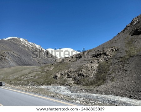 A white snow on the mountain with green the mountain on side the road like beautiful amazing view blue sky
