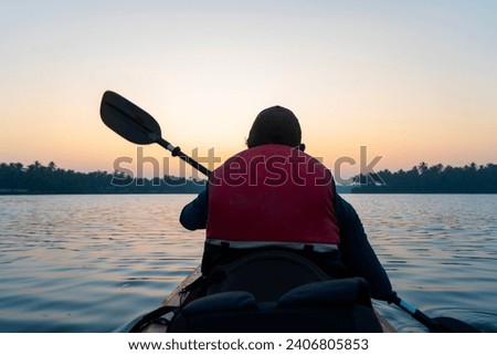 Man kayaking at Kavvayi lake Kannur, Kerala travel and tourism background Royalty-Free Stock Photo #2406805853