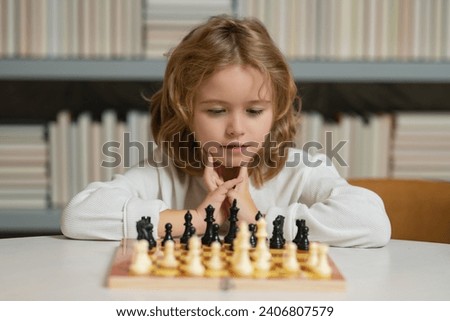 Little child chessman play chess game, checkmate. Kids early development. Boy kid playing chess at home. Portrait close up, funny face. Royalty-Free Stock Photo #2406807579