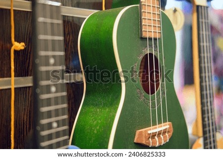 Green ukulele in a music shop, small green guitar