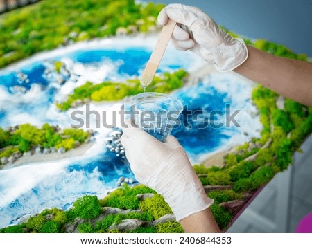 The process of making the art decor of epoxy resin, natural stones and moss Royalty-Free Stock Photo #2406844353