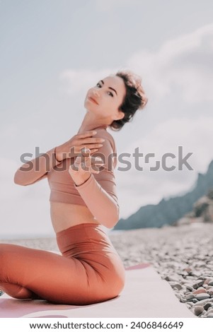 Middle aged well looking woman with black hair, fitness instructor in leggings and tops doing stretching and pilates on yoga mat near the sea. Female fitness yoga routine concept. Healthy lifestyle