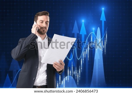 Attractive young european businessman talking on the phone and looking at paper growing forex chart with bright upward arrow on blurry pixel background. Success, financial growth and trade concept