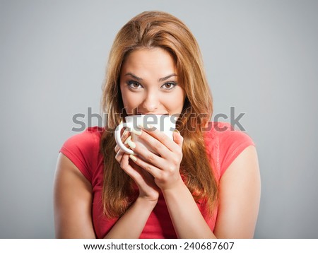 Close-up of beautiful young woman drinking coffee or tea. Studio  shot