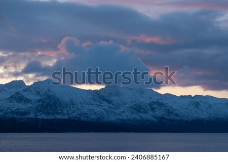 Purple and orange hues during a lightly clouded sunset over the arctic mountains