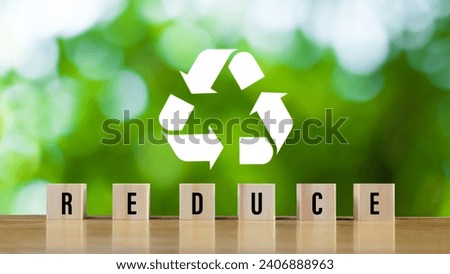 icons related to reduce, on green background with wooden blocks the concept of reduce, reuse, recycle symbols, ecological waste management and sustainable and economical lifestyles.