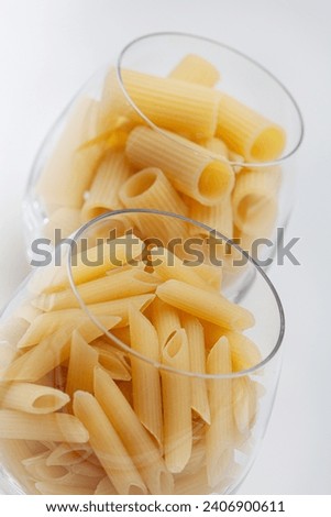 Raw pasta in two glasses