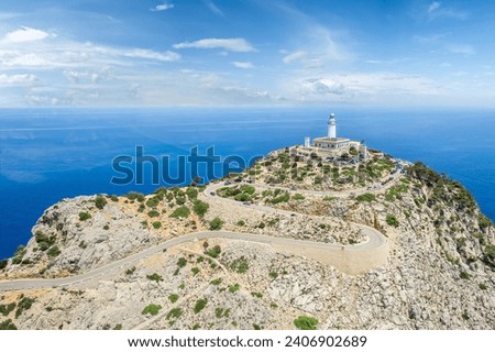 Landscape with the towering Formentor Lighthouse, perched atop Majorca rugged cliffs, offering breathtaking views over the azure Mediterranean.