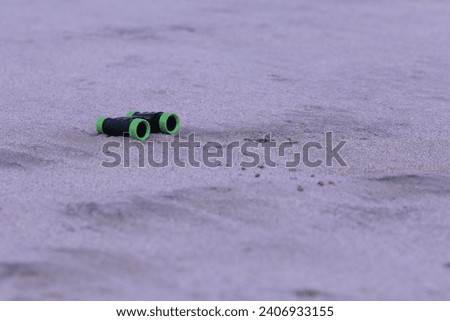 Pirate binoculars stranded on a white beach