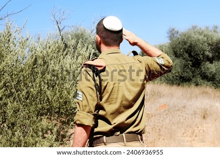Religious Israeli Soldier with staff sergeants Israel Defense Forces saluted in nature. Concept patriotic photo: IDF, Tzahal,  Soldier, Israel Royalty-Free Stock Photo #2406936955