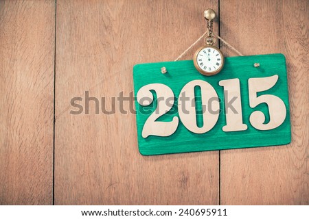 New Year date signboard with retro bronze watches on wooden wall for greeting card background
