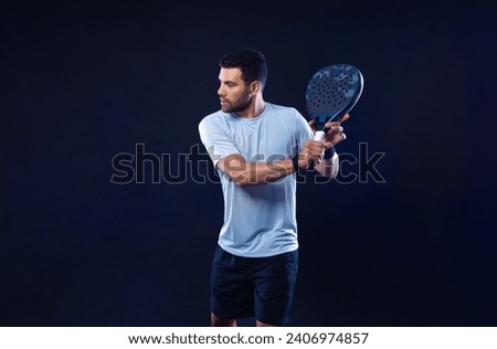 Padel tennis player with racket. Man athlete with paddle racket on black background. Sport concept. Download a high quality photo for sports website.