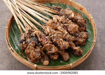 Goat satay served with peanut sauce or soy sauce with sliced shallots, cucumber and cayenne pepper