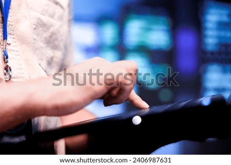 Developer in front of blurry background mainframe rows delivering web content to clients. Programmer in data storage business using laptop to make sure systems are in sound condition, close up