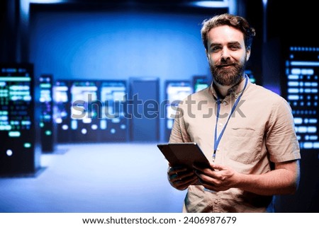Portrait of technician making sure servers in cloud computing business service are correctly equipped, to provide redundancy and automatic failover of clusters to minimize failure of hardware Royalty-Free Stock Photo #2406987679