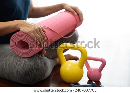Young asian woman holding a yoga mat with fitness sport training club background, sport and healthy lifestyle concept