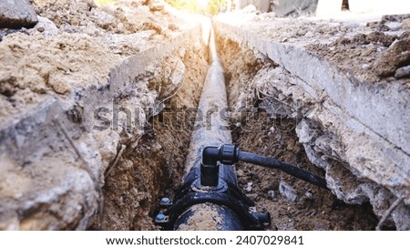 The street of the city is torn down.Construction underground utilities in street site, Repair,  laying water pipes or replacing sewer pipes Installation of plumbing, sanitation and drainage systems. Royalty-Free Stock Photo #2407029841