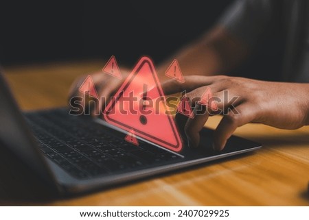 User is using computer with triangle caution warning sign for notification error and maintenance concept. Hacker attacks and hacking data, cyber crime, Ransomware, Phishing, Spyware, cybersecurity. Royalty-Free Stock Photo #2407029925