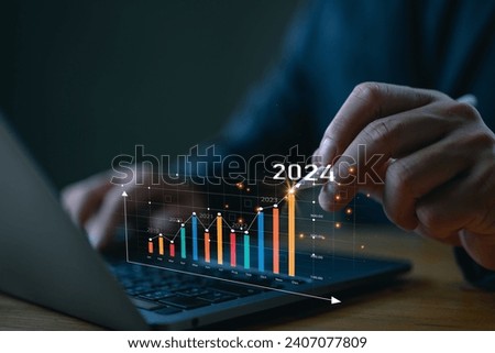 Businessman investor analyzes profitability of working companies with digital augmented reality graphics, positive indicators in 2024, businessman calculates financial data for long-term investments. Royalty-Free Stock Photo #2407077809