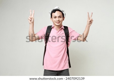 happy asian man backpacker give victory finger sign gesture. digital nomad and travelling concept. on isolated background
