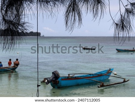 Portrait of a small child playing on a boat parked on the beach, in the Mentawai Islands, Indonesia.