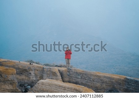 Young woman traveler taking a beautiful landscape at ijen crater, Travel lifestyle concept